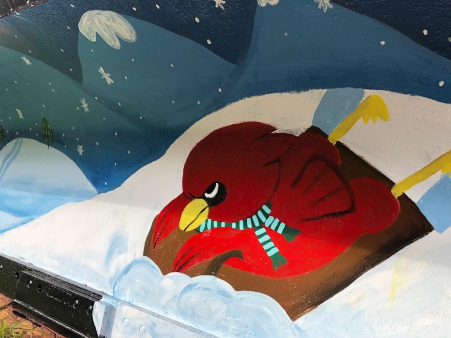 Our mascot, the Cardinal sledding down a snow covered hill on the mural. 