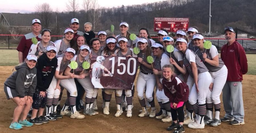 The softball team gathering for a picture to celebrate Kate Rittenbaughs 150 hits.