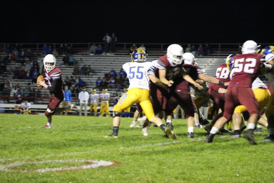 Quarterback, Josh Leininger, scrambles out of the pocket to try and get his pass off to one of his receivers.