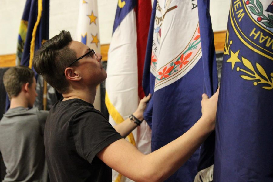 Cadet 2nd Lieutenant John Harig adjusting the state flags after underclassmen cadets set them out for display.