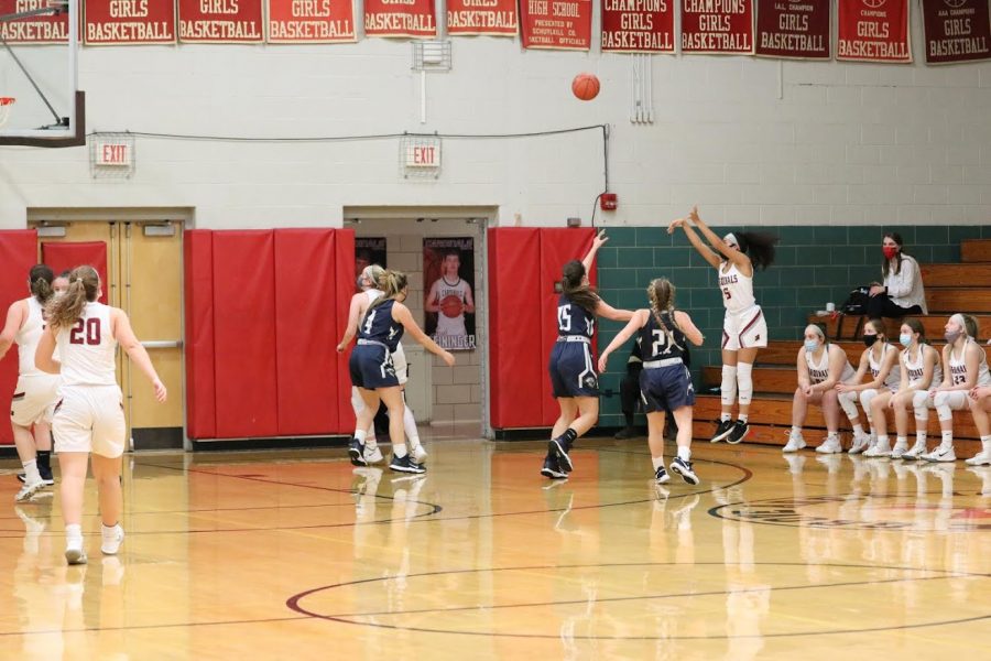 Mikaili Donmoyer shoots a three over two defenders.