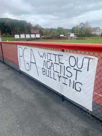 A poster on the fence along the track in Cardinal Stadium. The poster was to promote the white out football game. The white out was a Success.