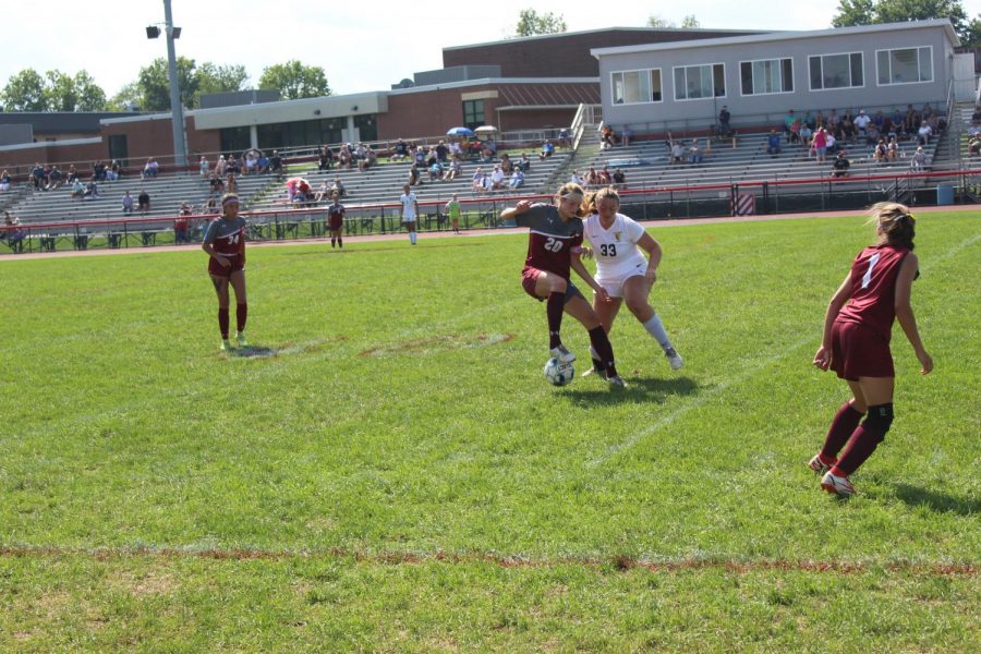 Abby Frew, senior, dribbles the ball away from the defender.