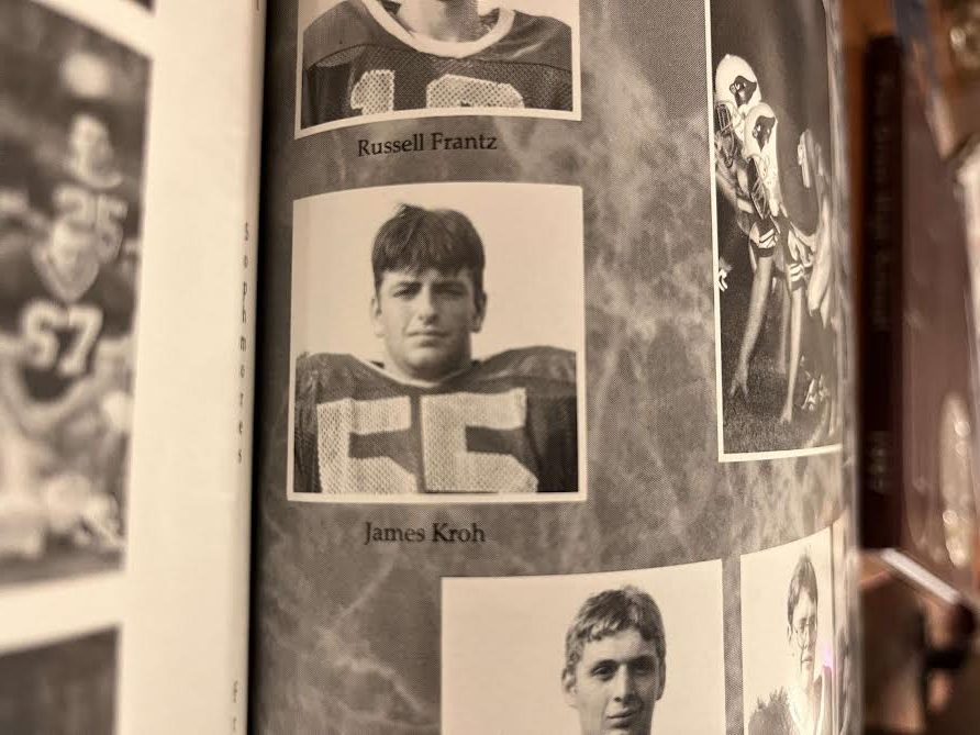 James Kroh father of Mason Kroh, junior, poses for football picture in his uniform.