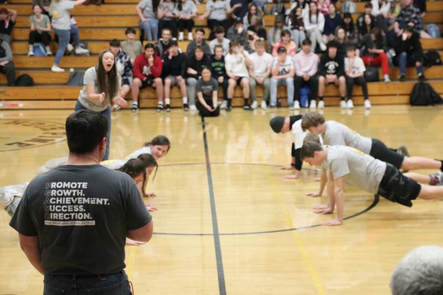 Mr.Newswanger leads the Cheerleaders vs. Wrestlers in the Push-Up Contest.