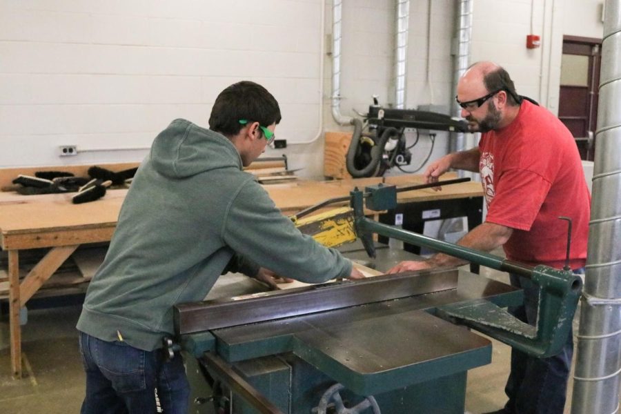 Mr. Mack helps Brad Anderson, senior, use the rip cutter for Anderson’s current project.