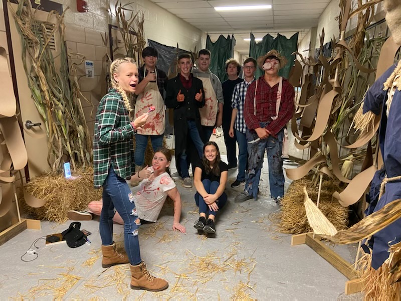 Emily Fisher, senior, and her group posing for a picture during the set up of their Children of the Corn room in the Haunted School.