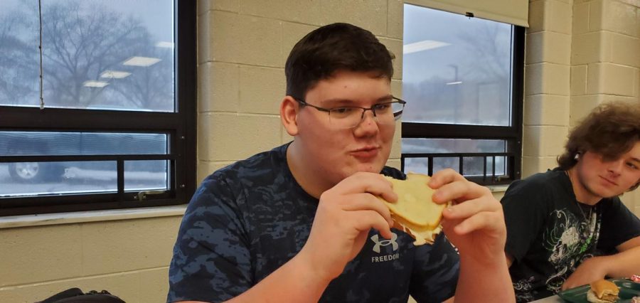 Zachary Pominville, junior, eating his grilled cheese sandwich during A lunch.