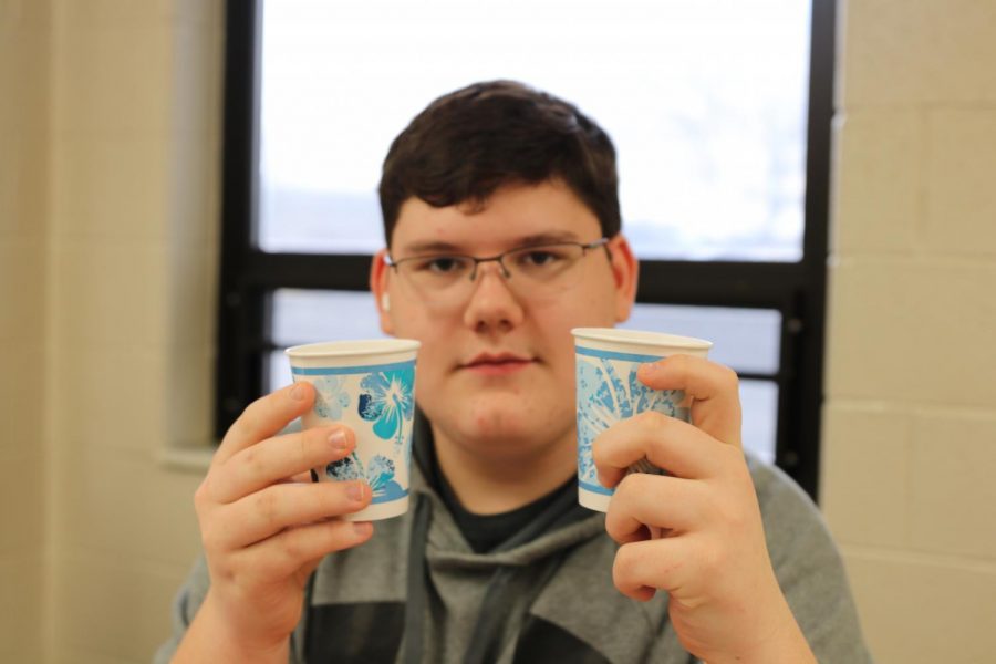 Zachary Pominville, junior, holds a cup of Sprite and Starry up before he compares the two sodas.