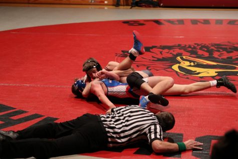 Cade Schneck, senior, attempts to pin his opponent. I wanted to get that win and get it fast, says Schneck.