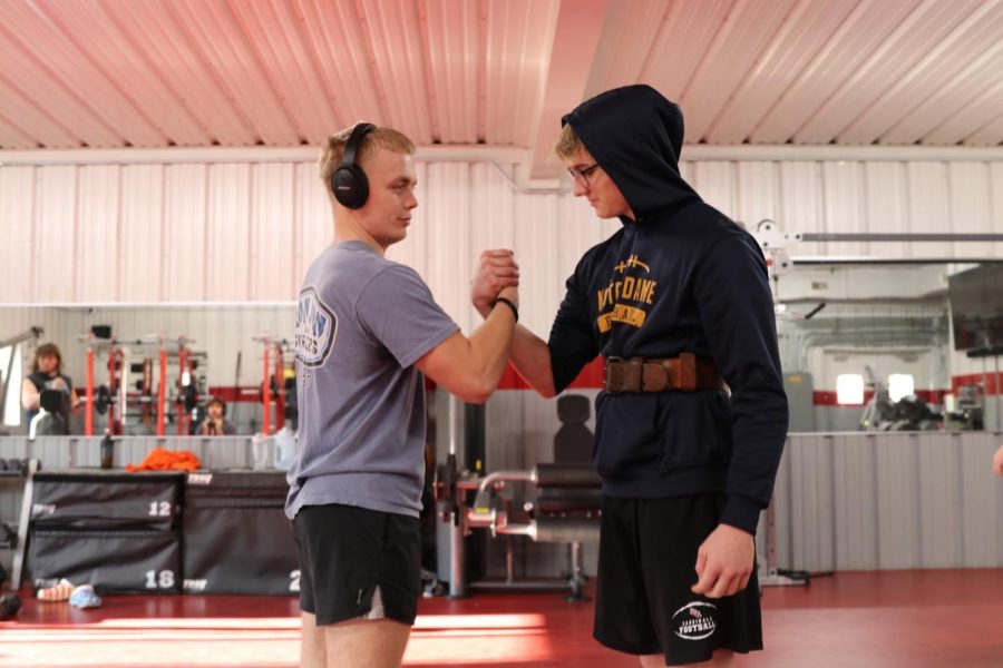 Evan Kerenda, junior, and Ty Drumheller, junior, share a hand shake as they prepare. The two of them are hyping each other up for squats.” Evan and I have been lifting together for awhile and always push each other to get better. says Ty Drumheller.