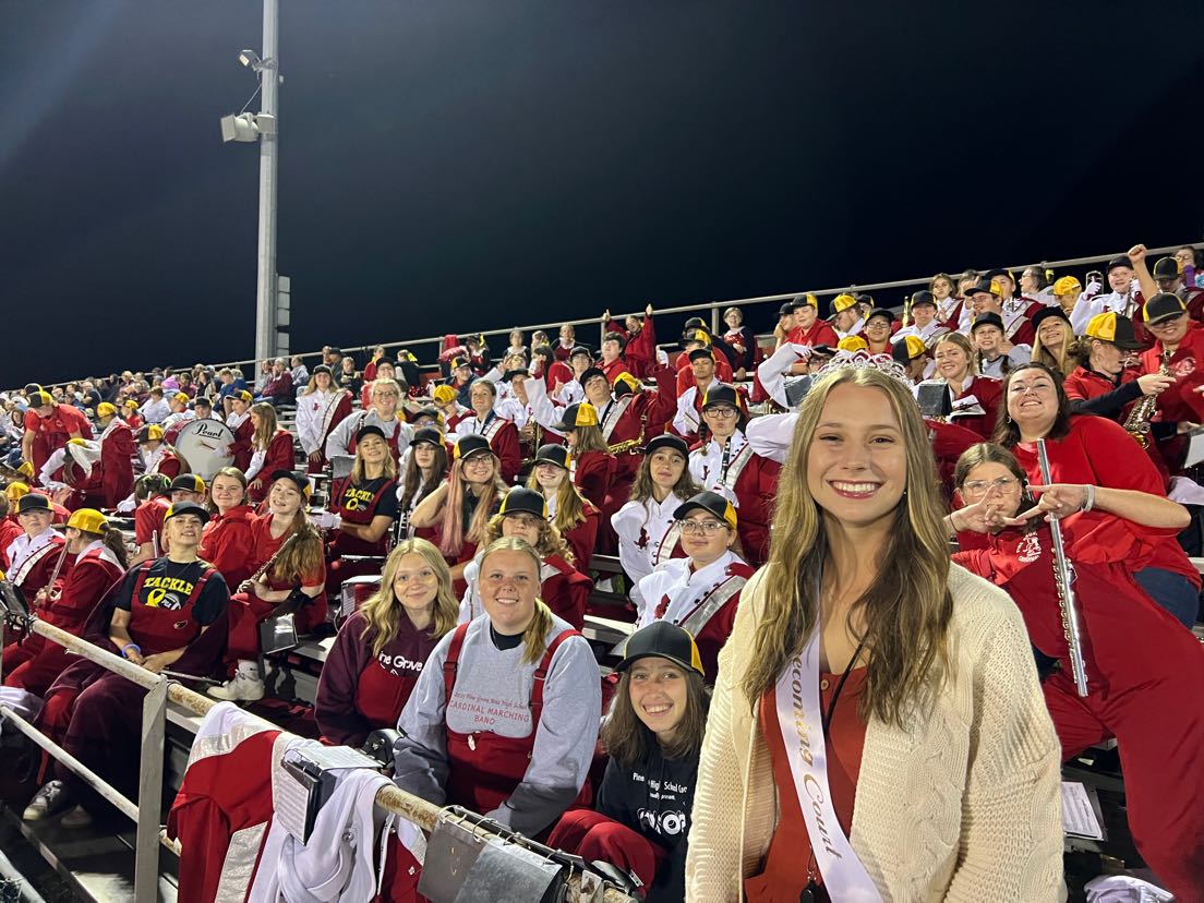 Taylor+Ott+poses+in+front+of+members+of+the+Cardinal+Marching+Band+with+her+homecoming+queen+tiara.+As+a+drum+major%2C+Ott+helped+lead+the+members+of+the+band+to+the+field+for+the+halftime+ceremony.
